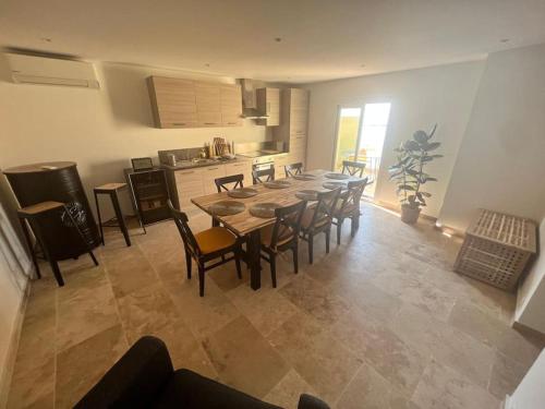 une salle à manger avec une table et des chaises et une cuisine dans l'établissement Entre les citronniers et la mer, à Èze