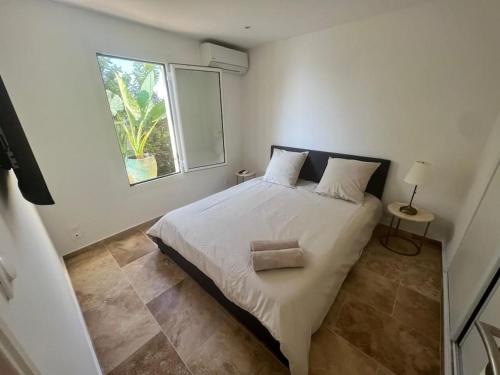 une chambre avec un grand lit blanc avec une fenêtre dans l'établissement Entre les citronniers et la mer, à Èze