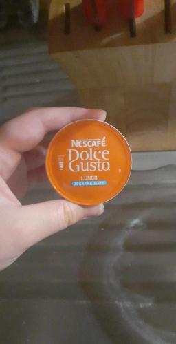 une main tenant un frisbee orange avec les mots neglect cookie gusteus dans l'établissement Simplicité et confort, à Saint-Fons