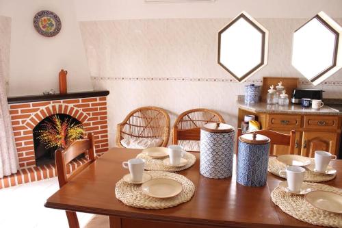 a dining room with a table and a fireplace at Apalaches Trail House in Oleiros