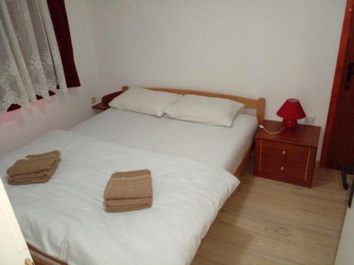 a bedroom with two beds with towels on them at Stan na dan Apartman Kozarac in Kozarac
