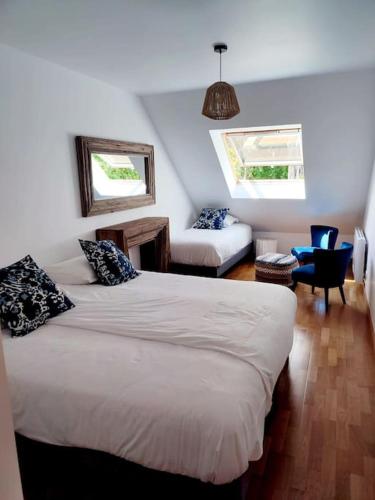 - une chambre avec deux lits, un canapé et une chaise dans l'établissement Gîte du Parc, à Barneville-Carteret