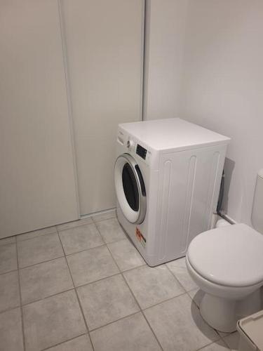 La salle de bains est pourvue de toilettes et d'un lave-linge. dans l'établissement Gîte du Parc, à Barneville-Carteret