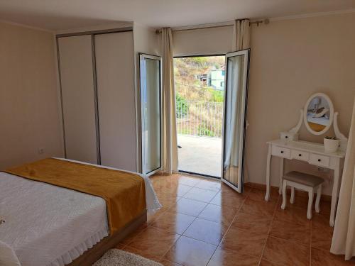 une chambre avec un lit et une porte coulissante en verre dans l'établissement Success House, à Calheta