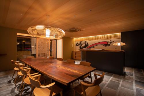 a dining room with a large wooden table and chairs at Hotel Legasta Kyoto Higashiyama Sanjo in Kyoto
