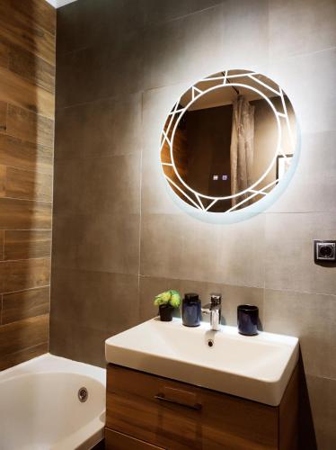 a bathroom with a sink and a mirror at Riverside LUX Apartment in Pirot