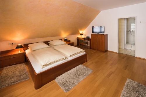 a bedroom with a large bed and a television at Hotel & Gasthaus Nagel GmbH in Südlohn
