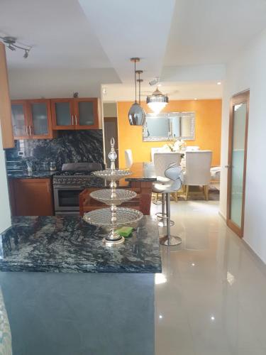 a kitchen and living room with a table and a dining room at El apartamento que tu necesita para disfrutar tu vacaciones in Villa Mella