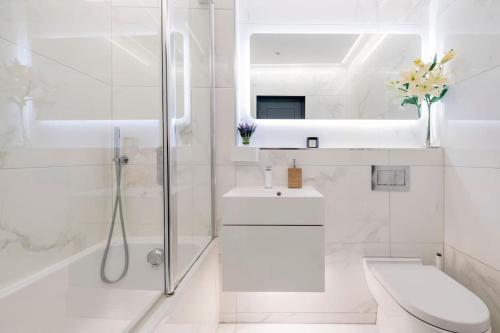 a white bathroom with a shower and a sink at Immaculate 3 Bed Apartment with Private Entrance in Inverleith in Edinburgh