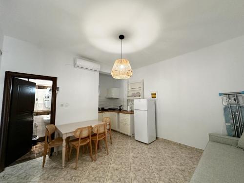 a kitchen with a table and chairs and a refrigerator at Petra Mare Apartments in Alyki