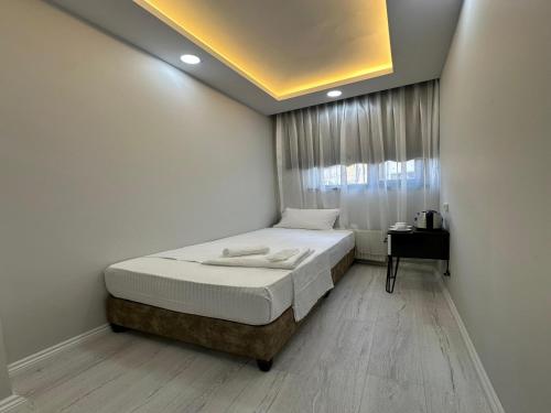 a small bedroom with a bed and a window at Kosova Hotel in Istanbul