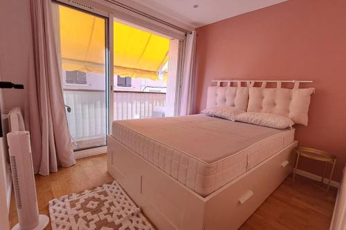 un lit dans une chambre avec une grande fenêtre dans l'établissement T3 Bandol- 20m mer & commerces, à Bandol