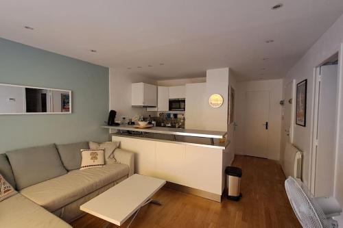 un salon avec un canapé et une cuisine dans l'établissement T3 Bandol- 20m mer & commerces, à Bandol