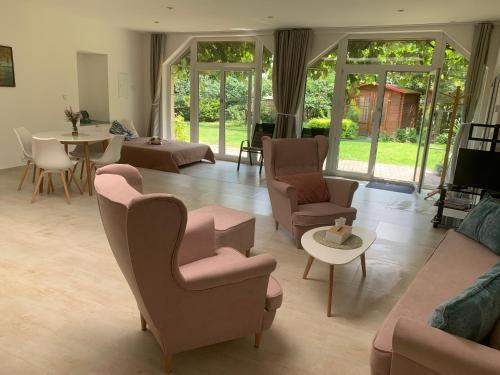 a living room with chairs and a couch and a table at Garden apartment RELAX in Doksy