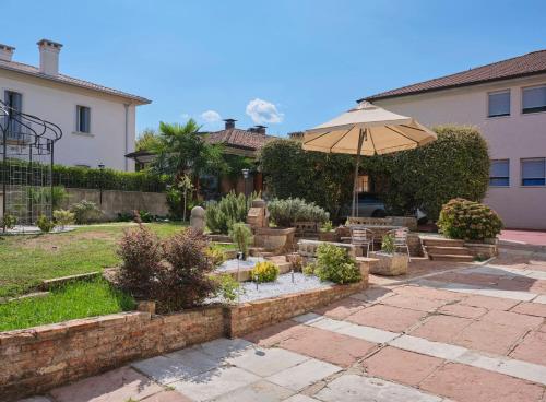 a garden with an umbrella in a yard at VILLA MARGHERITA in Pieve di Soligo