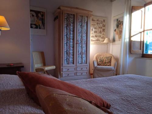 a bedroom with a bed and a chair and a window at La Torretta Historical Home in Casperia