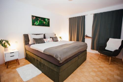 a bedroom with a large bed and a chair at Exklusive Goethe-Suite am Brocken by Meis in Wernigerode Zentral in Wernigerode