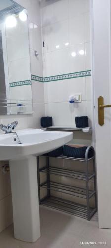 a white bathroom with a sink and a mirror at HolaMar in Benicarló