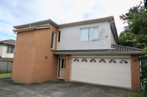 a house with a white and orange garage at 5 Bedroom sweet House 82A Richardson Road in Auckland