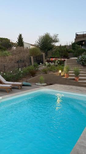 une piscine bleue avec une chaise et une terrasse dans l'établissement Magnifique appartement petit havre de paix, à Fréjus