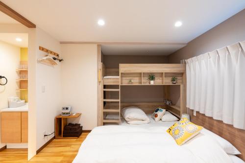 a small bedroom with a bed and shelves at Asakusa Stay in Tokyo