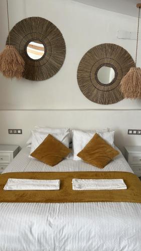 a bedroom with a bed with two mirrors on the wall at Tu Casita Rural in Valdilecha