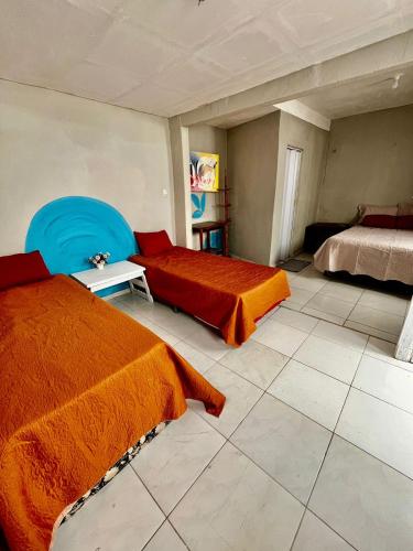 a bedroom with two beds and a blue chair at Recanto Canoa - Canoa Quebrada in Aracati