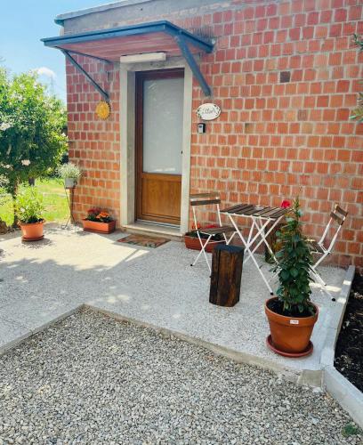 a patio with a table and chairs and a brick building at L'Olivo in Ponteginori