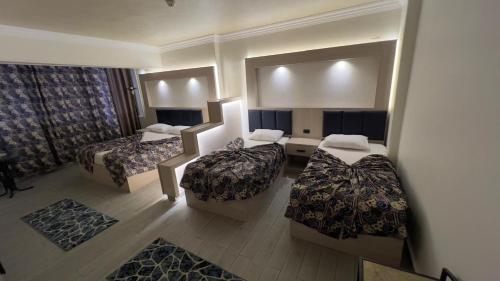 a hotel room with two beds and a mirror at Havana Hotel Cairo in Cairo