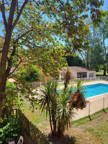 - une piscine dans une cour à côté d'une clôture dans l'établissement Appartement du Lac - Village Camarguais, à Arles