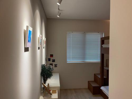 a living room with a window and a staircase at Chuncheon Diary Stay in Chuncheon