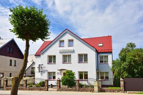 una casa blanca con techo rojo en Vilaverona, en Palanga