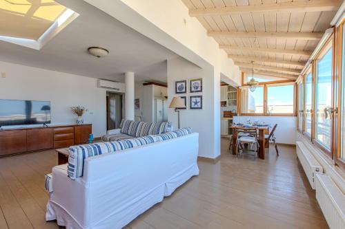 a living room with white furniture and a table at Platanias Memories Apartment in Platanias