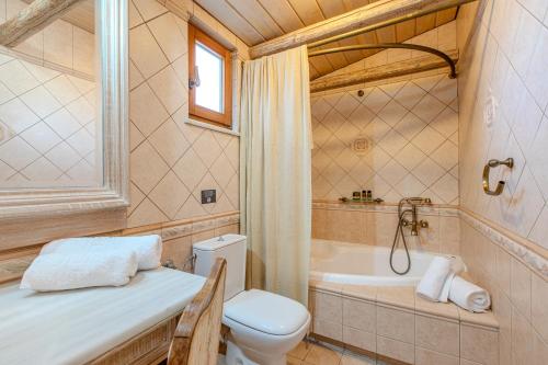 a bathroom with a toilet and a bath tub at Platanias Memories Apartment in Platanias