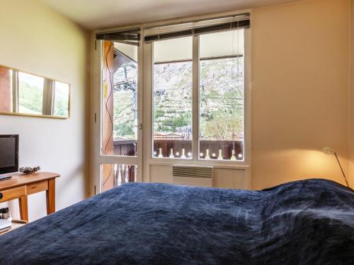 une chambre avec un lit et une fenêtre dans l'établissement Appartement contemporain de standing skis aux pieds, à proximité du village des enfants - Val d'Isère - FR-1-694-171, à Val dʼIsère