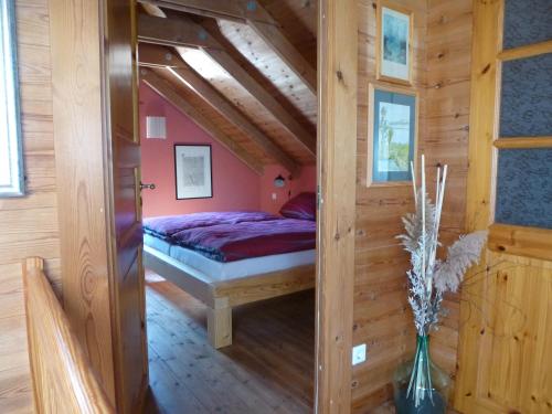 a bedroom with a bed in a wooden house at Haus Peenehagen in Groß Gievitz