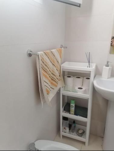 a bathroom with a sink and a towel hanging on a wall at Apartamento de lujo Martil in Martil