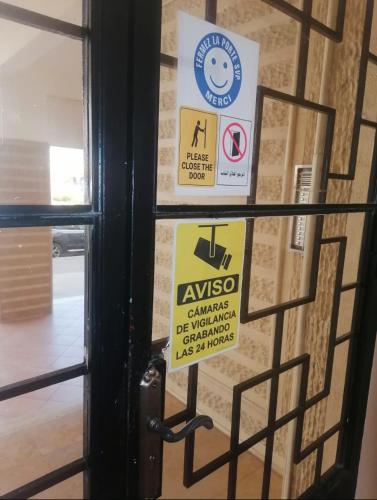 a door with signs on it in a building at Apartamento de lujo Martil in Martil