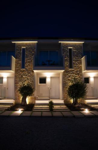 a building with two white garage doors at night at Montedarena Hotel in Pulsano