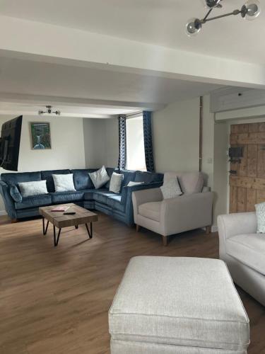 a living room with a blue couch and a table at Cosy countryside cottage in Aberystwyth