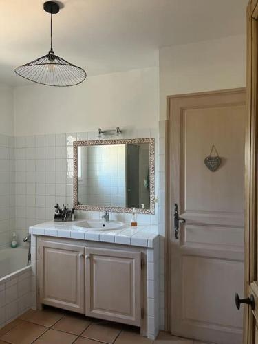 une salle de bain avec un lavabo, un miroir et une baignoire dans l'établissement Jolie maison provençale avec piscine, à Jouques