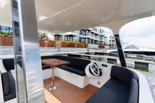 a boat deck with a bench and a table at Sol Marina Resort Wyspa Sobieszewska I - LoftAffair Collection in Wiślinka