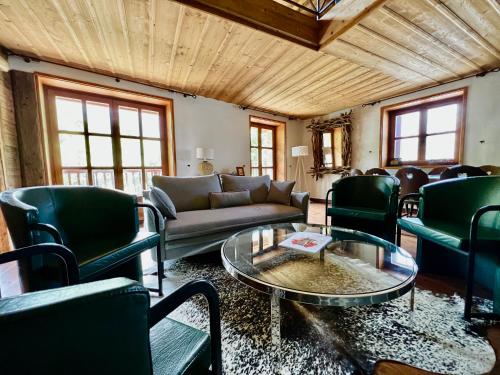 un salon avec un canapé, des chaises et une table dans l'établissement Chalet Altus, à Sainte-Foy-Tarentaise
