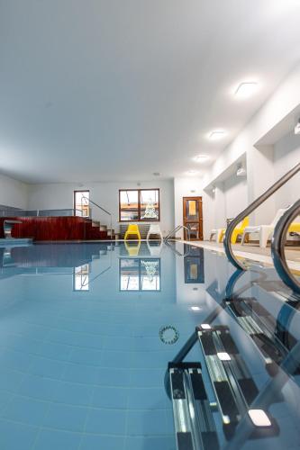 a large swimming pool with a blue tile floor at Resort EuroPark Fundata in Fundata