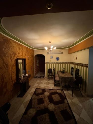 a living room with a table and chairs and a ceiling at Apartment in assiut with AC in Al Walīdīyah