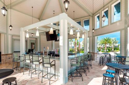 a covered patio with tables and chairs and a bar at Renewed Luxury Townhouse with private pool in Kissimmee