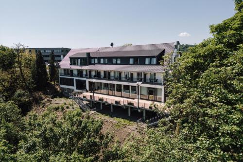 a large building on a hill with trees at Si-View Doppelzimmer Siegen Zimmer 15 - Hotel in Siegen