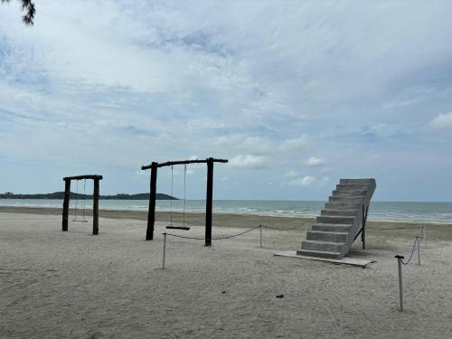 a beach with a swing set on the beach at Penthouse Desaru Beach 5G Wifi Netflix Pool View in Bandar Penawar