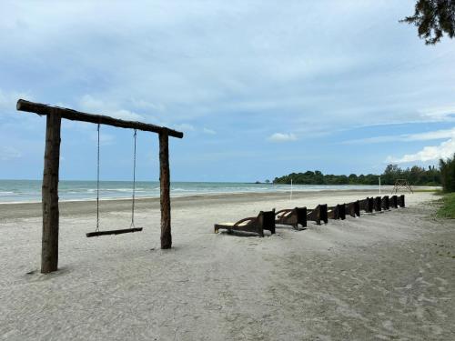 an empty swing set on a sandy beach at Penthouse Desaru Beach 5G Wifi Netflix Pool View in Bandar Penawar