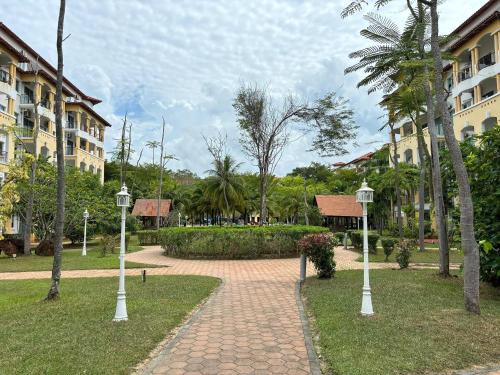a walkway in a park with palm trees and buildings at Penthouse Desaru Beach 5G Wifi Netflix Pool View in Bandar Penawar
